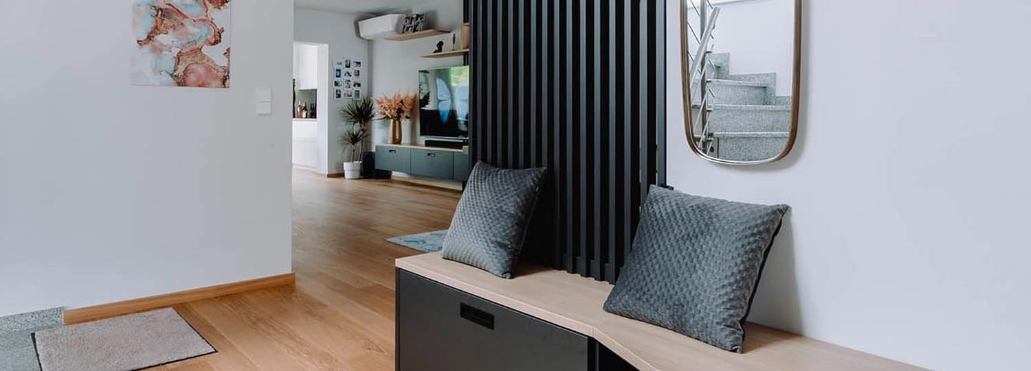 Aménagement design d'une grande entrée de maison avec banquette et rangement déco
