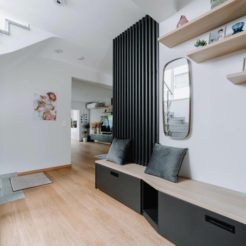 Aménagement design d'une grande entrée de maison avec banquette et rangement